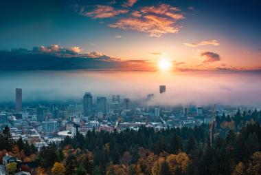 A photograph of Portland downtown with rolling fog and autumn foliage in shining sunrise and colorful clouds